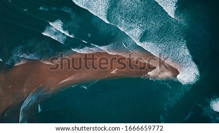 Waves rolling over sand bar drone shot