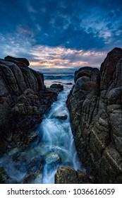 Waves rushing between rocks atsunset