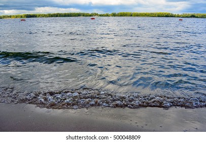 Waves Rushing In on sandy beach, close up. Volga river in Samara city