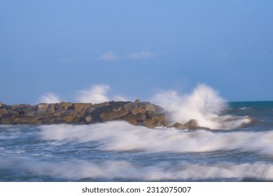 The waves from the sea hit the rocks in spray. - Shutterstock ID 2312075007