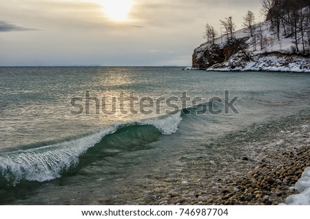 Waves and splash on Lake Baikal with rocks and trees in Uzuri bay. Russia, Siberia