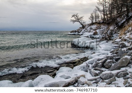 Waves and splash on Lake Baikal with rocks and trees in Uzuri bay. Russia, Siberia
