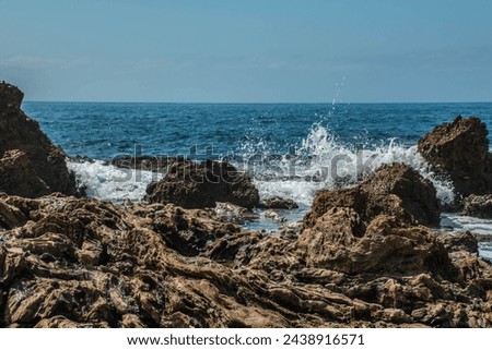 Waves splash on rugged rocks along the Pacific coast.