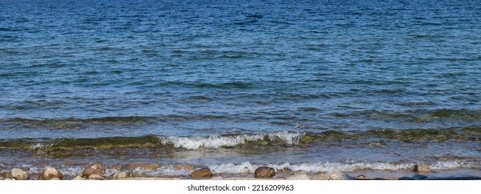 Waves Splashing, Hitting Rocks On Shoreline Lake Beach On A Sunny Summer Day