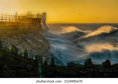 Waves start to increase as Storm Eunice gathers momentum around Porthcawl lighthouse in South Wales UK
