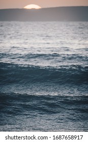 Waves at sunset with blurry sunset