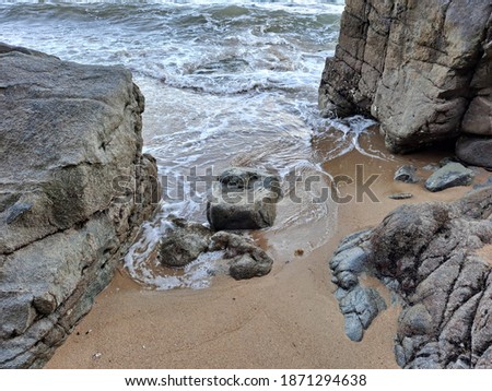 Waves through the rocks and wet sand
