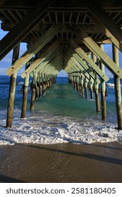 waves underneath a beach pier 