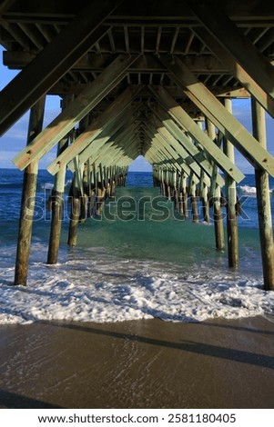 waves underneath a beach pier 