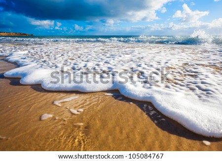 Waves wash over golden sand on Australian beach