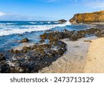 Waves Washing Exposed Lava Reef Below Sea Cliffs on Glass Beach, Port Allen, Kauai, Hawaii, USA