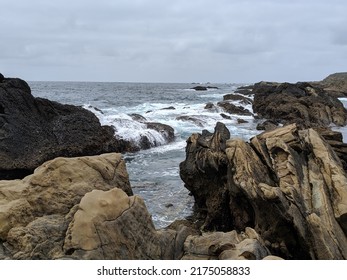 Waves Washing Over Rocks At The Beach On A Cloudy Day. Muted Color Landscape View In California.