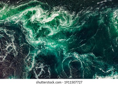 Waves of water of the river and the sea meet each other during high tide and low tide. Whirlpools of the maelstrom of Saltstraumen, Nordland, Norway - Shutterstock ID 1911507727