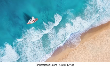 Waves and yacht from top view. Turquoise water background from top view. Summer seascape from air. Top view from drone. Travel-image - Shutterstock ID 1303849930