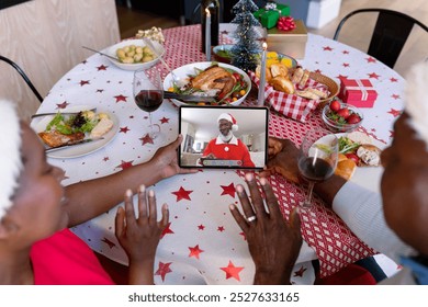 Waving african american senior couple making tablet christmas video call with man in santa suit. christmas, festivity and communication technology. - Powered by Shutterstock