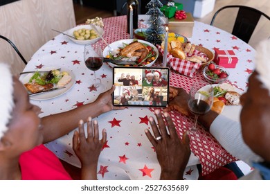 Waving african american senior couple making tablet christmas group video call with diverse friends. christmas, festivity and communication technology. - Powered by Shutterstock