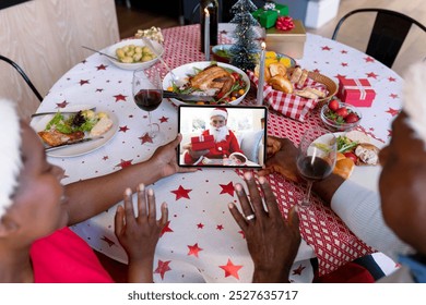 Waving african american senior couple making tablet christmas group video call with santa claus. christmas, festivity and communication technology. - Powered by Shutterstock