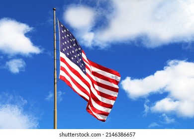 a waving american flag blue sky america holiday flying windy pride symbol red white blue clear wind tall stars stripes