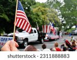 Waving an American flag at the Independence Day Parade on the 4th of July
