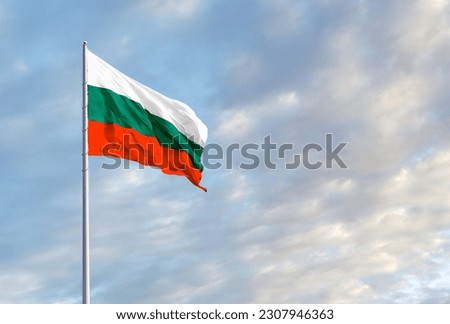 Waving Bulgarian flag against a blue sky with clouds and empty space for text. Room for text.