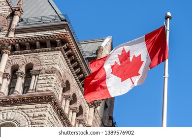 
The Waving Canadian Flag With Old City Hall In Background In Toronto, Canada