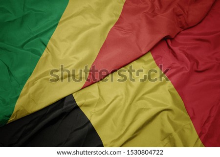 waving colorful flag of belgium and national flag of republic of the congo. macro