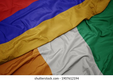 waving colorful flag of cote divoire and national flag of armenia. macro