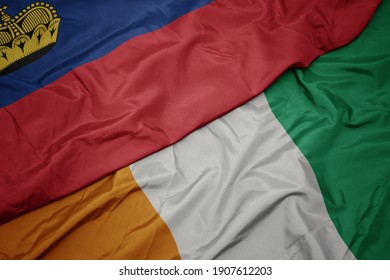 waving colorful flag of cote divoire and national flag of liechtenstein. macro