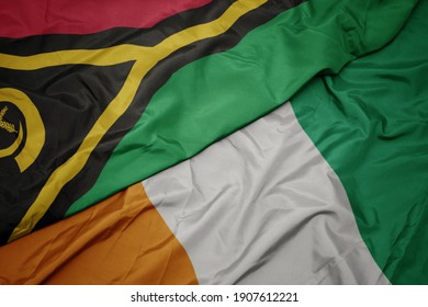 waving colorful flag of cote divoire and national flag of Vanuatu . macro