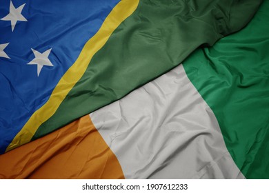 waving colorful flag of cote divoire and national flag of Solomon Islands . macro