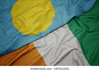 waving colorful flag of cote divoire and national flag of Palau . macro