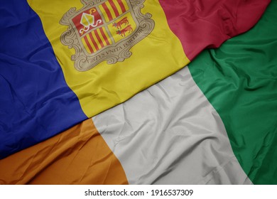 waving colorful flag of cote divoire and national flag of andorra. macro