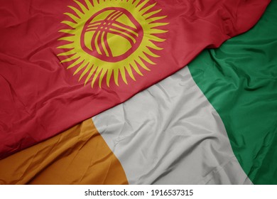 waving colorful flag of cote divoire and national flag of kyrgyzstan. macro