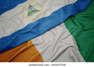 waving colorful flag of cote divoire and national flag of nicaragua. macro