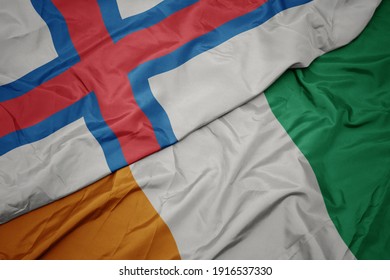 waving colorful flag of cote divoire and national flag of faroe islands. macro