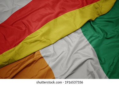 waving colorful flag of cote divoire and national flag of south ossetia. macro