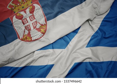 Waving Colorful Flag Of Scotland And National Flag Of Serbia. Macro