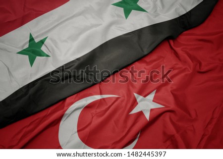 waving colorful flag of turkey and national flag of syria. macro