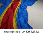 waving colorful national flag of democratic republic of the congo on a gray background.