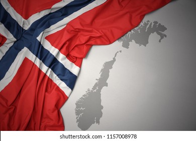 Waving Colorful National Flag Of Norway On A Gray Map Background.