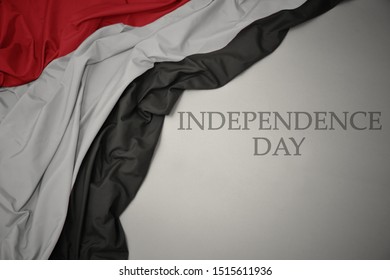 waving colorful national flag of yemen on a gray background with text independence day. concept
