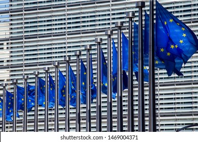 Waving European Union Flags Outside The European Commission Headquarters, Also Know As The Berlaymont Building, In Brussels, Belgium.