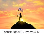 Waving flag of America at the top of a mountain summit against sunset or sunrise. American flag for Independence Day.