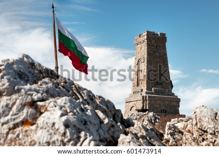 Waving flag of Bulgaria and Shipka memorial monument of Bulgarian liberty