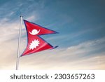 Waving flag of Nepal in beautiful sky. Nepal flag for independence day. The symbol of the state on wavy fabric.