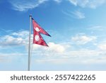 Waving flag of Nepal in blue sky. Nepal flag for Republic Day and Independence Day.