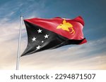 Waving flag of Papua New Guinea in beautiful sky. Papua New Guinea flag for independence day. The symbol of the state on wavy fabric.