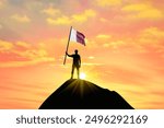 Waving flag of Qatar at the top of a mountain summit against sunset or sunrise. Qatar flag for Independence Day.