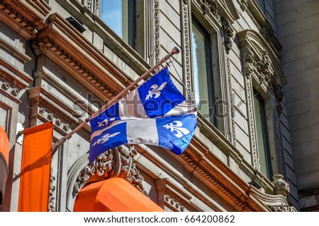 The waving flag of Quebec against the old building in old port of Montreal, Canada