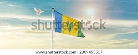 Waving flag of Saint Vincent and the Grenadines in beautiful sky. Saint Vincent and the Grenadines flag for independence day.